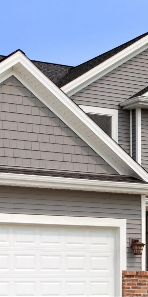 Modern home with stylish gray siding, white trim, and a double garage showcasing updated exterior design.