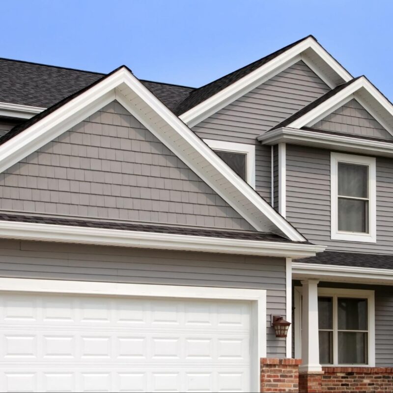 Modern home with stylish gray siding, white trim, and a double garage showcasing updated exterior design.